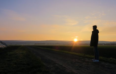 Ein Jugendlicher schaut in den Sonnenuntergang.